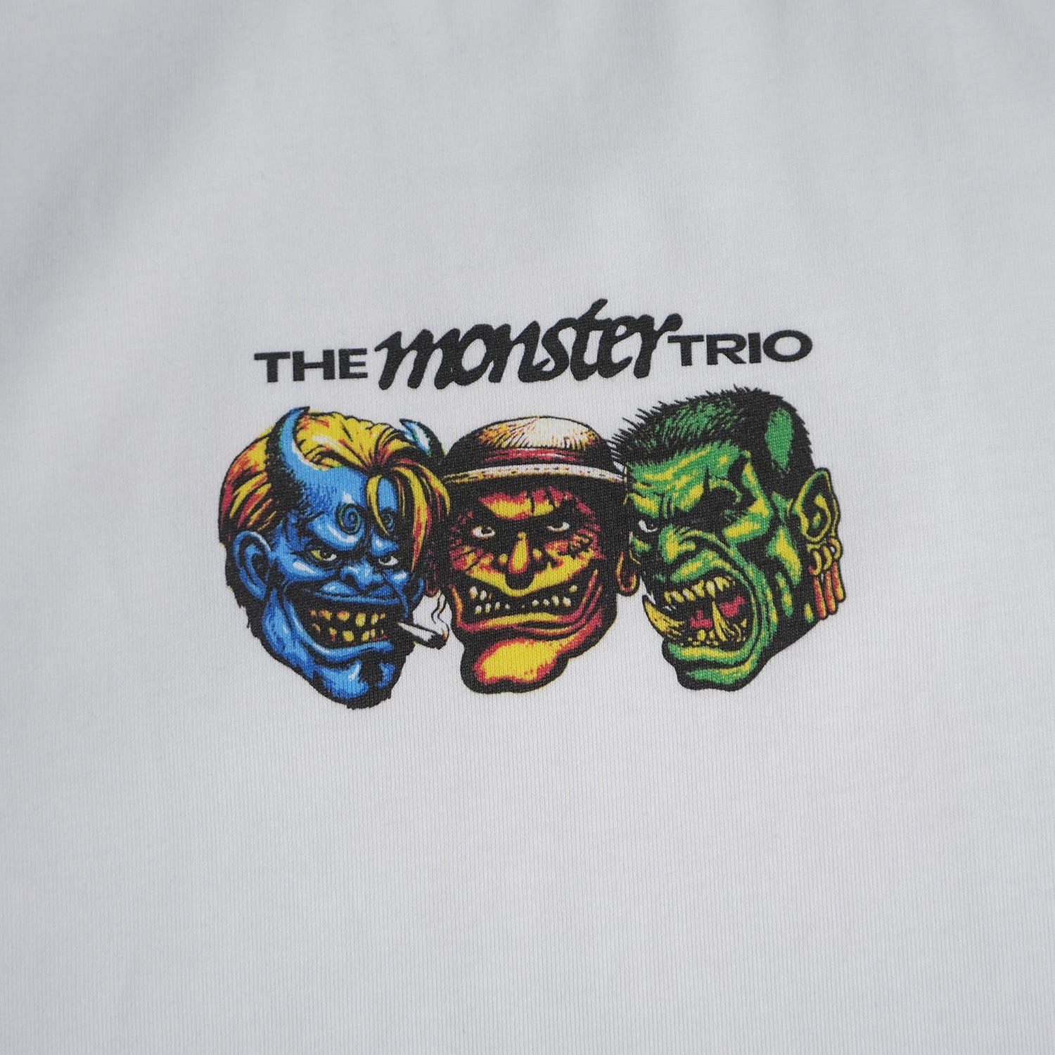Embroidered design of three colorful monster faces with 'The Monster Trio' text on a white background.