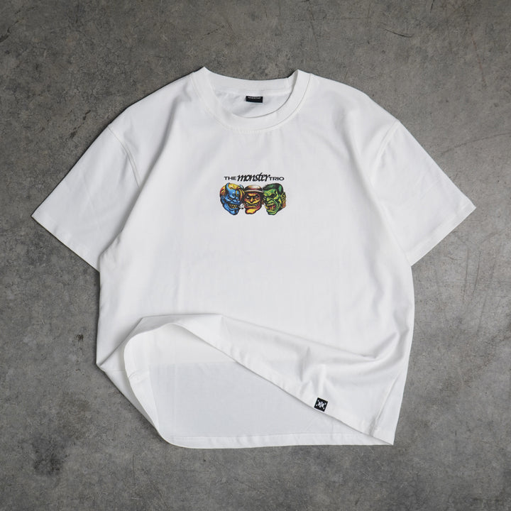 White t-shirt with colorful graphic design on a gray concrete surface