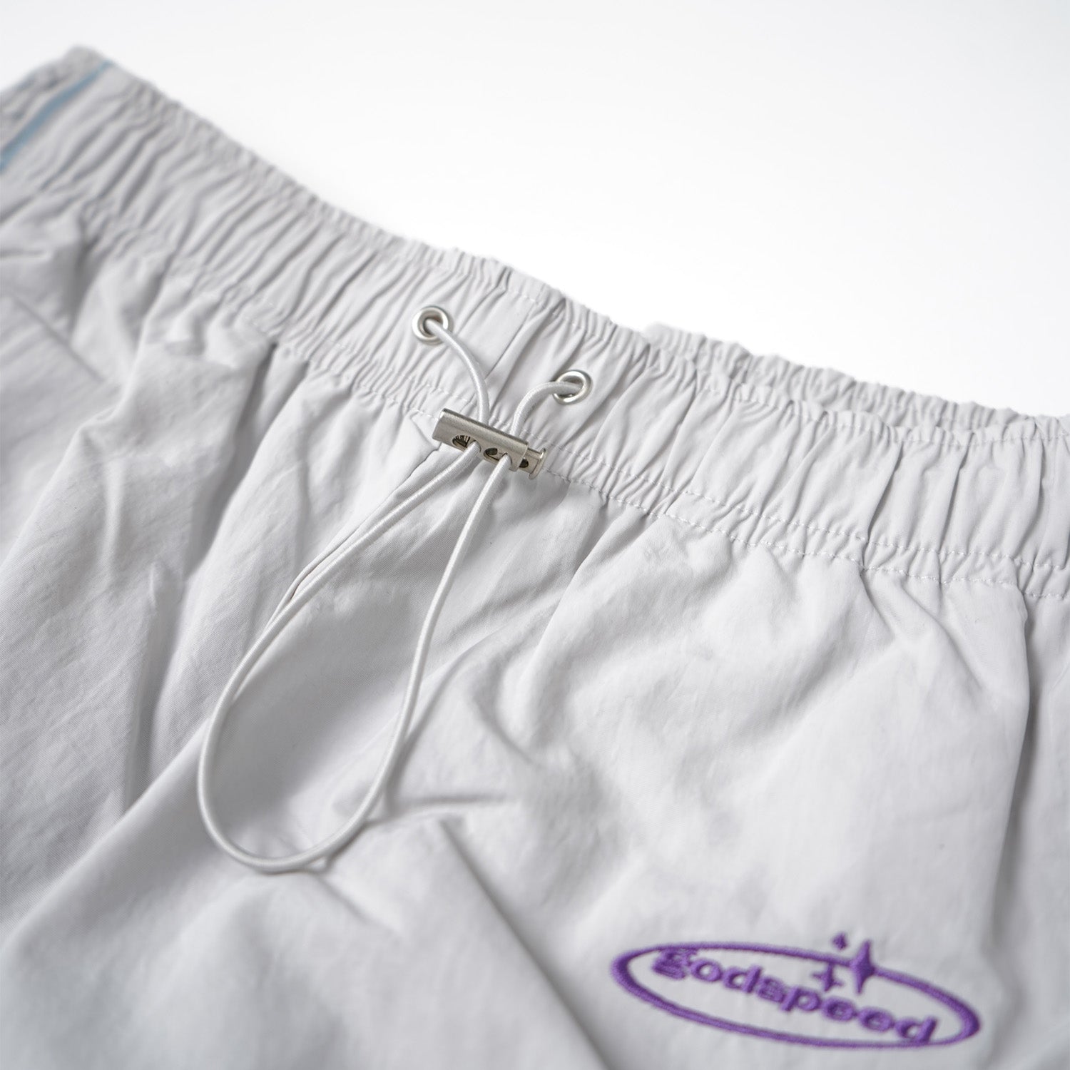 White drawstring shorts with a purple logo on a white background