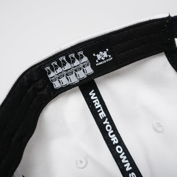 Close-up of a cap with branding and text on a white background