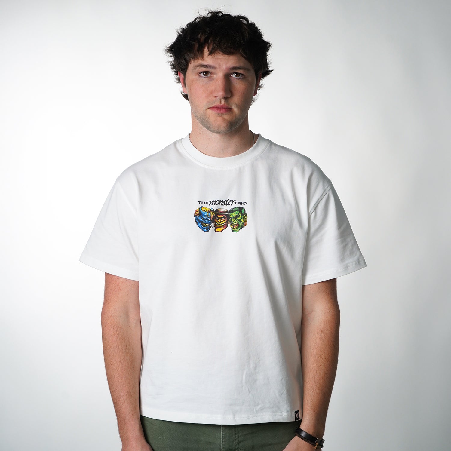 Person wearing a white t-shirt with colorful graphic design on a plain background