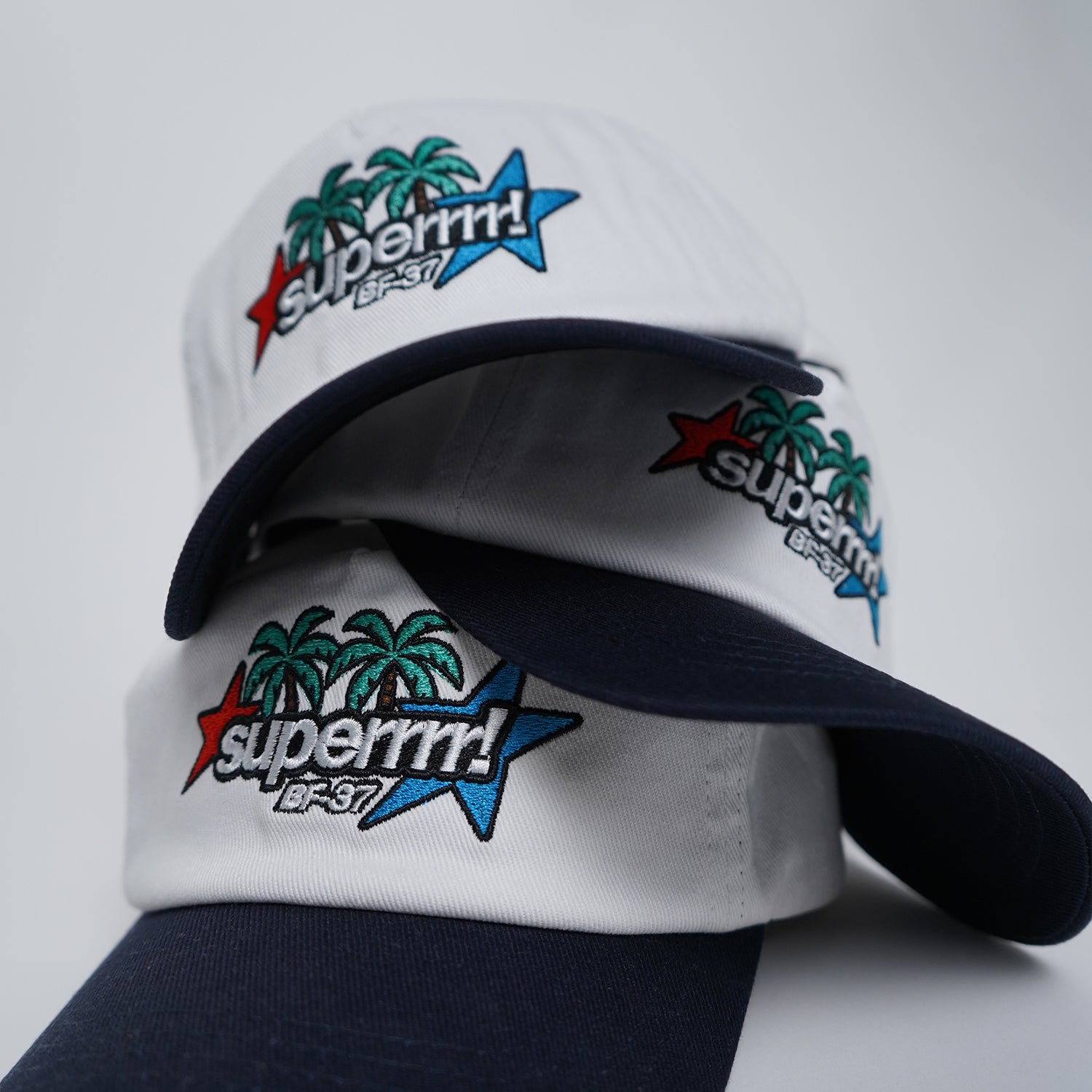 White and navy cap with colorful 'superrrrr!' branding on a light gray background