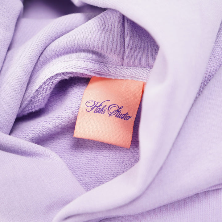 Close-up of a lavender fabric with a brand label.