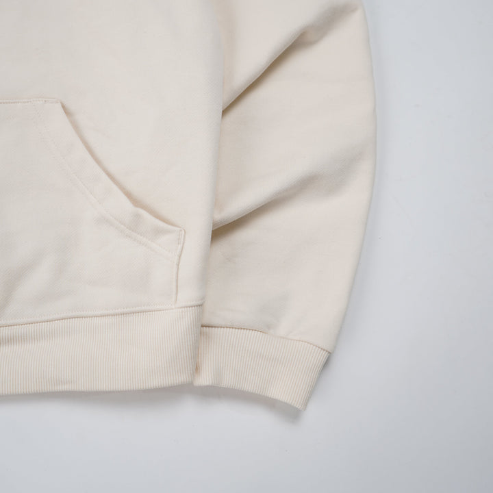 Beige shorts with a brand logo on a light gray background