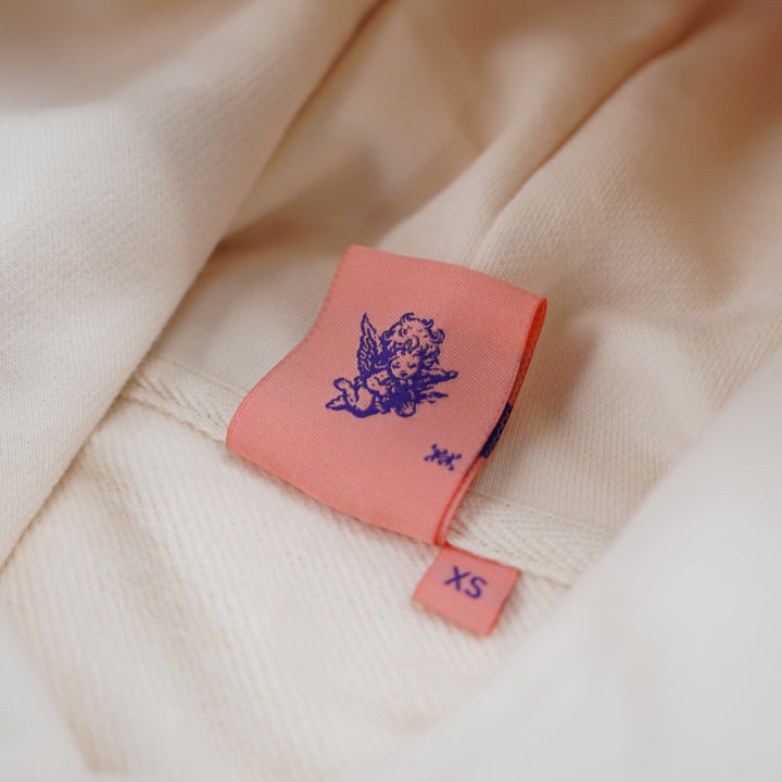 Close-up of a pink label with a logo on a beige fabric background
