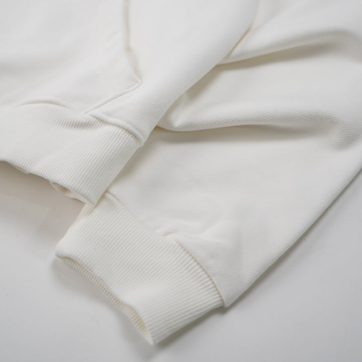 Close-up of a white sweatshirt on a light gray background