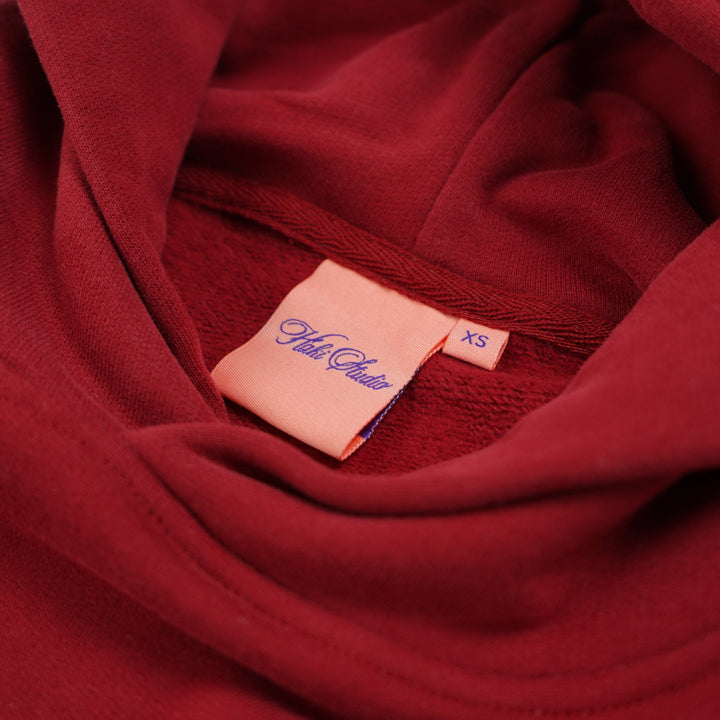 Close-up of a red fabric with a visible tag on a plain background