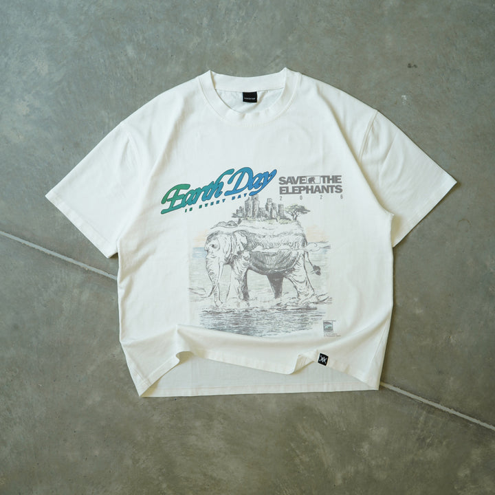 White t-shirt with graphic design and text on a gray concrete surface